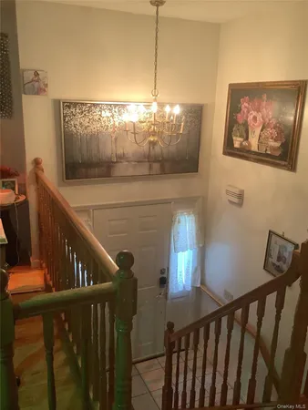 a view of staircase with railing and a chandelier