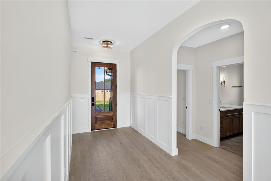 414 Blume Road Anderson, SC 29625 - Photo 7 of 50 Elegant wainscoting and smooth wood flooring define this welcoming entryway with its graceful arched pass-through.