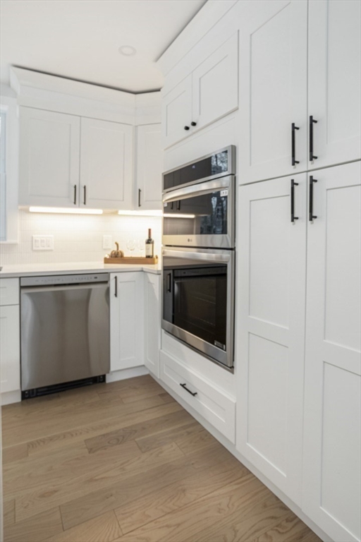63 Kellogg Street Framingham, MA 01701 - Photo 13 of 38 a kitchen with stainless steel appliances a stove a microwave and a hard wood floor