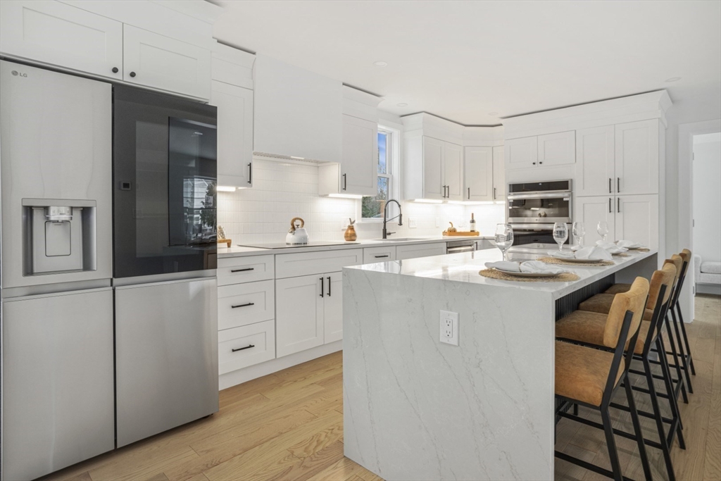63 Kellogg Street Framingham, MA 01701 - Photo 10 of 38 a kitchen with stainless steel appliances granite countertop a stove a sink a refrigerator a microwave and white cabinets