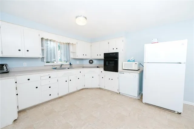 a kitchen with cabinets appliances a sink a counter top space and cabinets