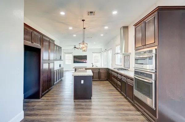 an empty room with wooden floor and ceiling fan