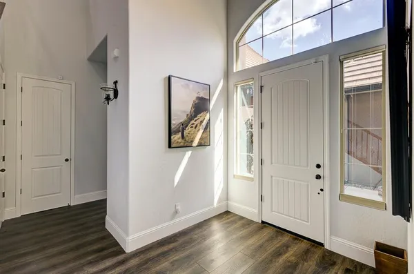 a view of a hallway with wooden floor and a bathroom