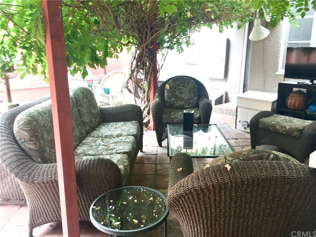 175 Granada Avenue Long Beach, CA 90803 - Photo 28 of 29 Backyard patio conversation area shaded by the westeria.
