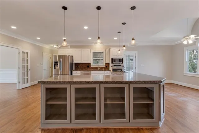 a view of a livingroom with wooden floor and a ceiling fan