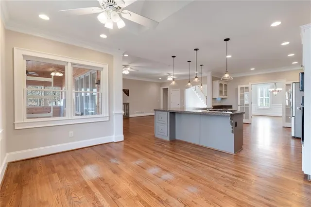 an empty room with windows and ceiling fan