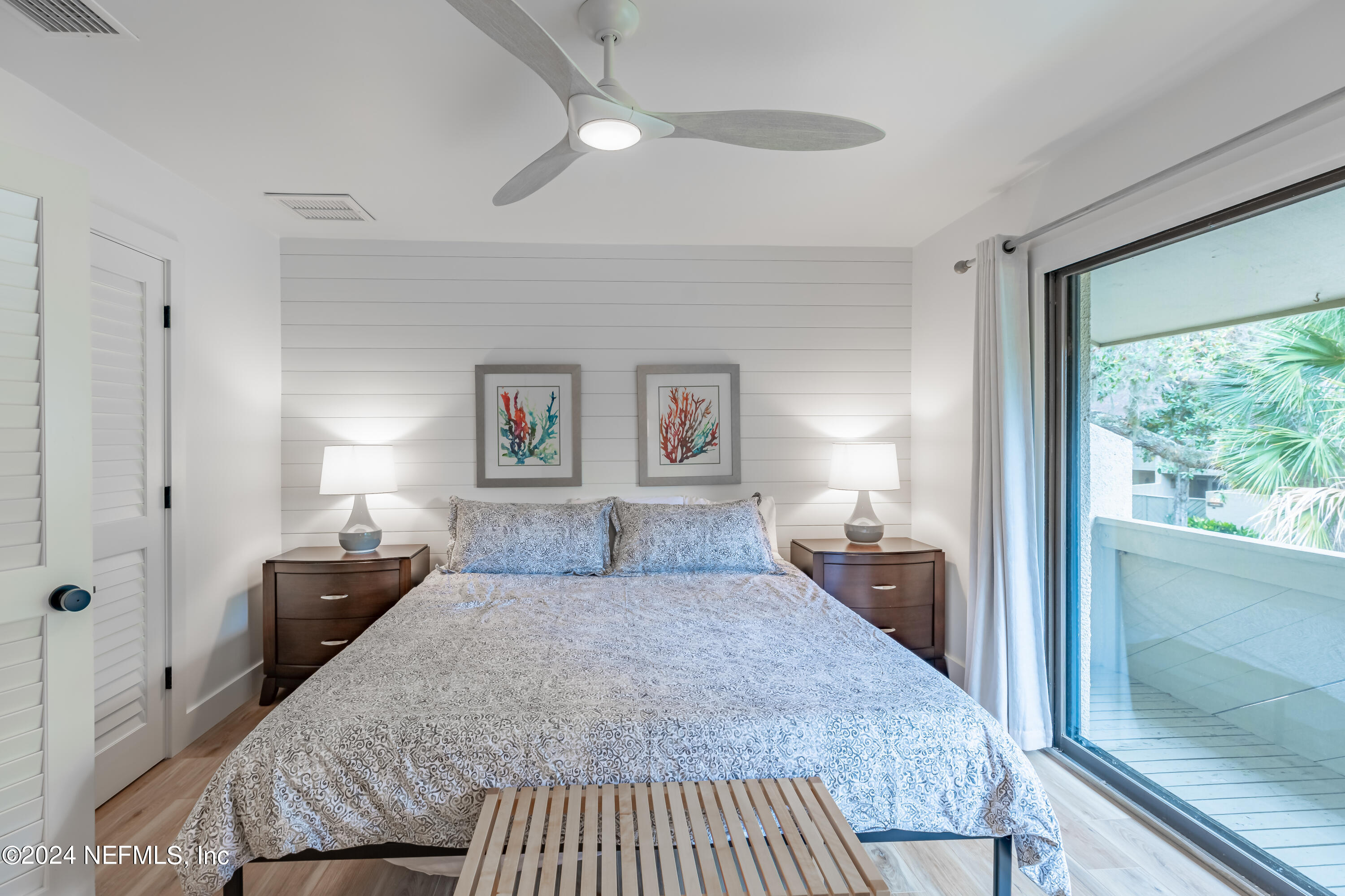 3025 Sea Marsh Road Fernandina Beach, FL 32034 - Photo 29 of 54 a bedroom with a large bed and a chandelier fan