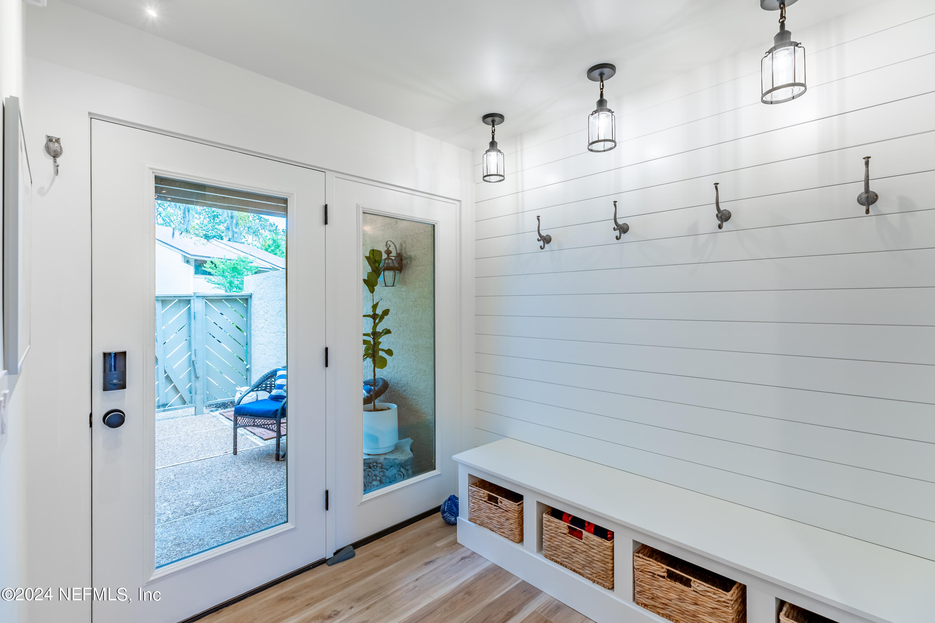 3025 Sea Marsh Road Fernandina Beach, FL 32034 - Photo 4 of 54 a hallway with wooden floor and glass door