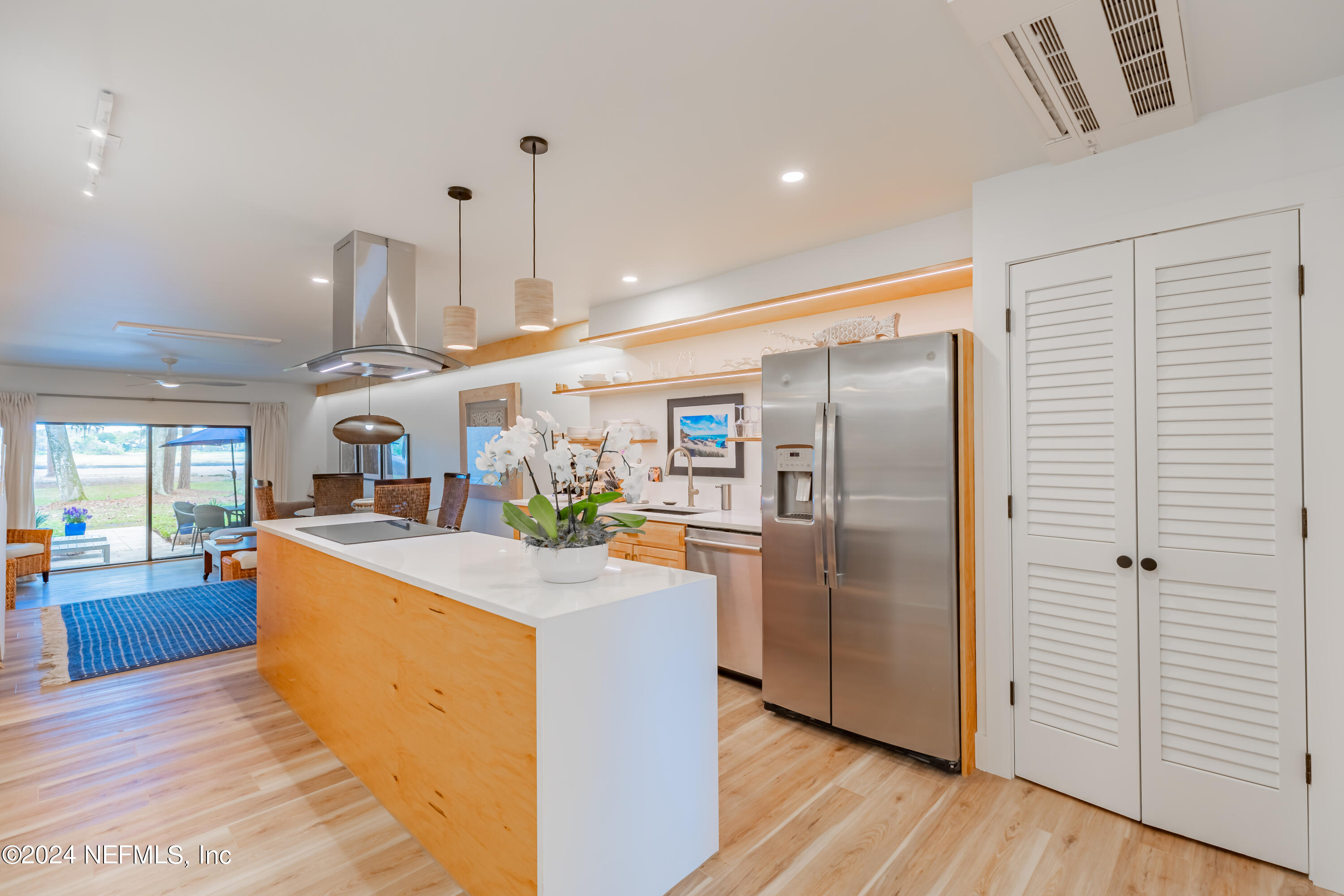3025 Sea Marsh Road Fernandina Beach, FL 32034 - Photo 5 of 54 a kitchen with stainless steel appliances granite countertop a refrigerator a sink dishwasher a stove and a dining table with wooden floor
