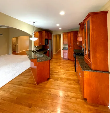 a living room with stainless steel appliances furniture a kitchen view and a refrigerator