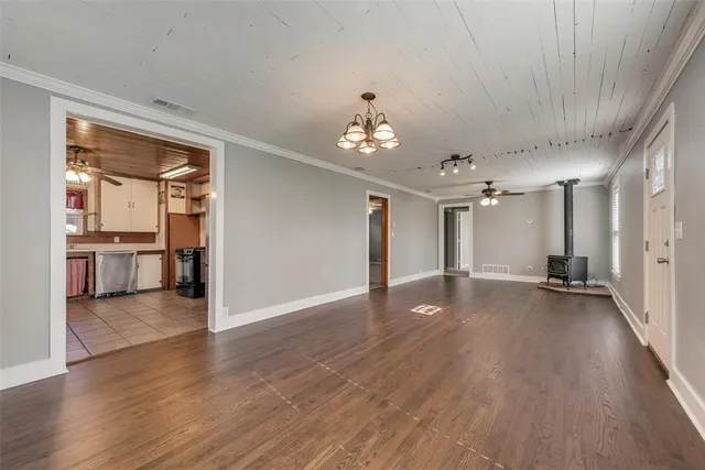 a view of a big room with wooden floor and a kitchen