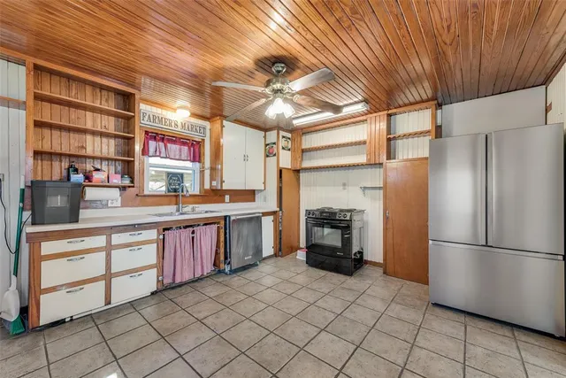a kitchen with stainless steel appliances granite countertop a refrigerator and a stove top oven