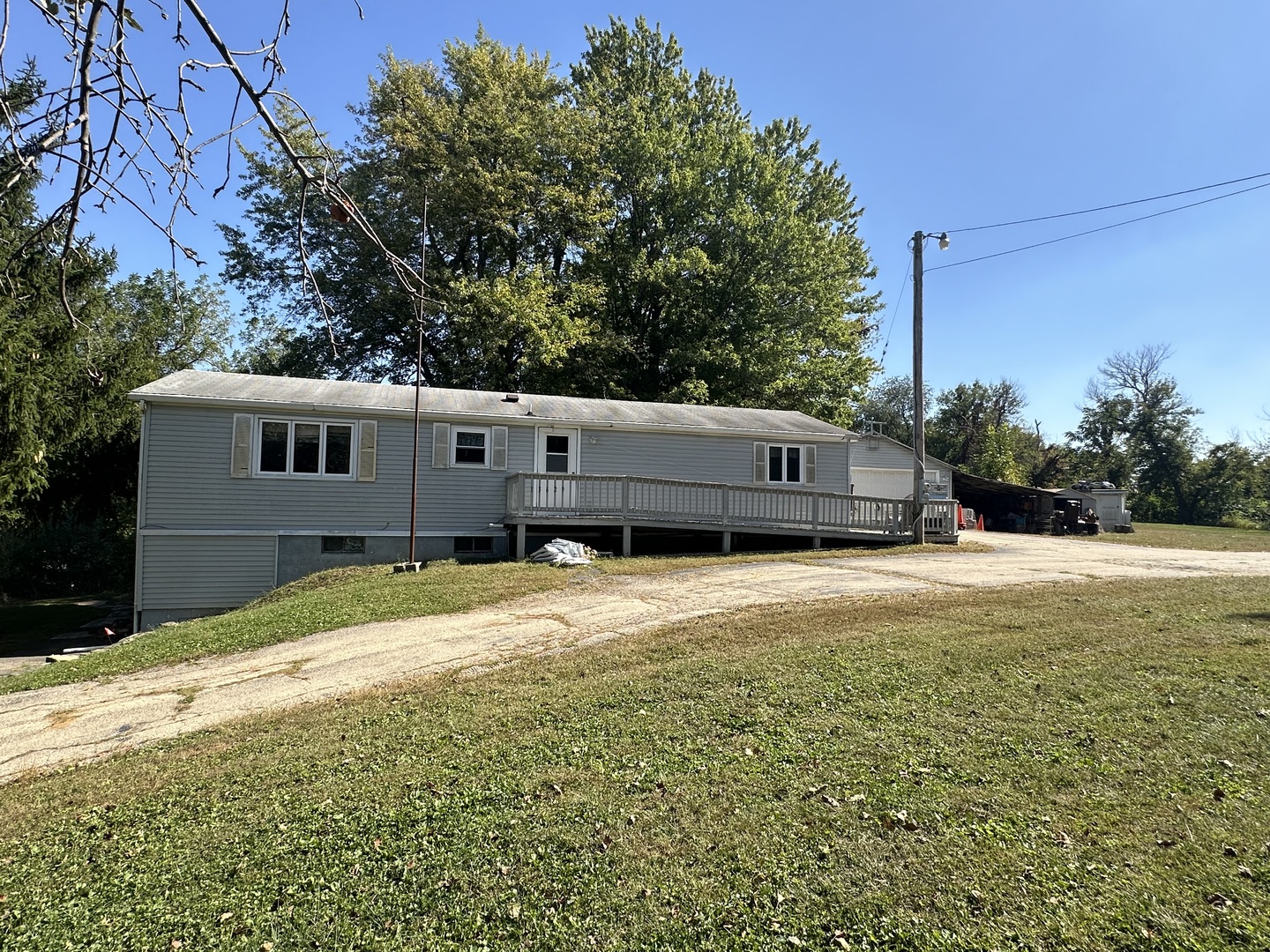 a backyard of a house with large trees and wooden fence