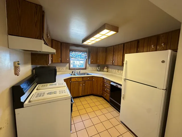 a kitchen with a refrigerator a stove top oven a sink and cabinets