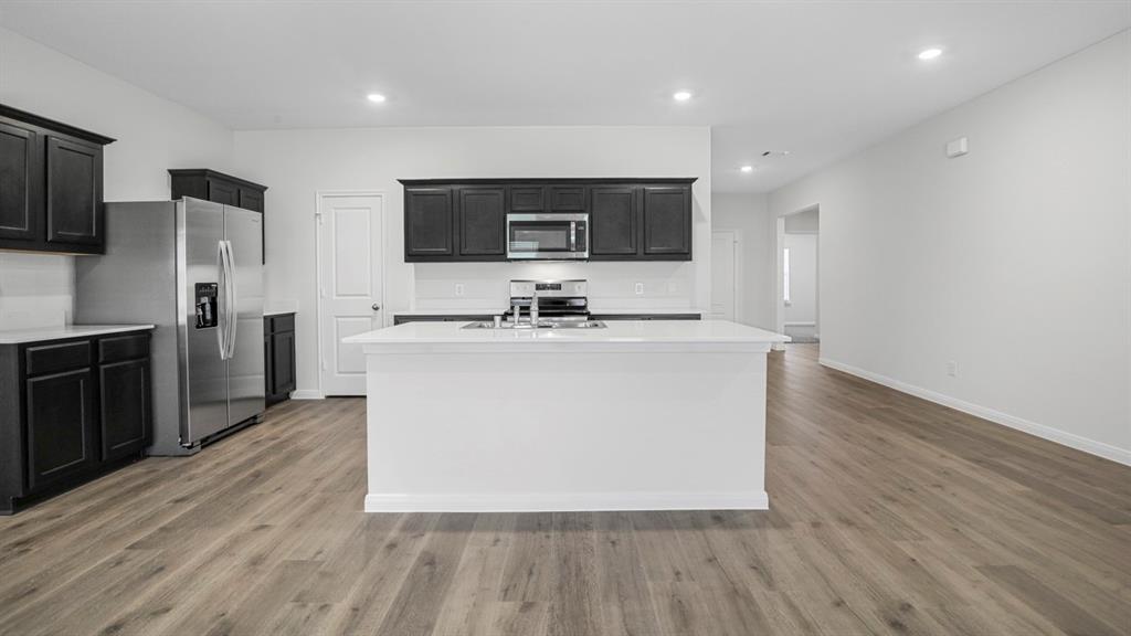 1921 Reveille Way Terrell, TX 75160 - Photo 15 of 30 a kitchen with stainless steel appliances granite countertop a sink a microwave a refrigerator and a stove