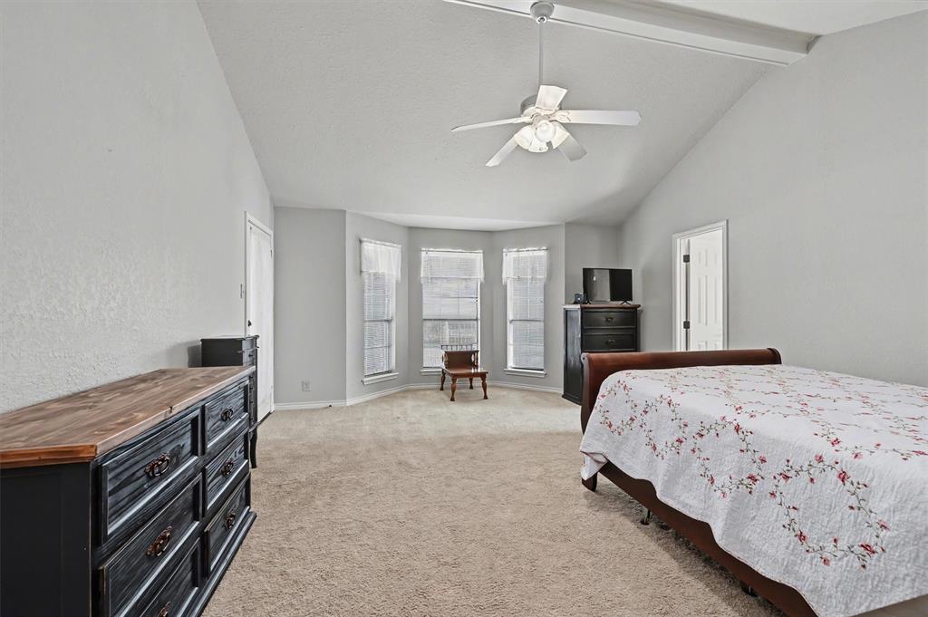 304 Trollinger Street Whitesboro, TX 76273 - Photo 14 of 25 a bedroom with a bed and a chandelier