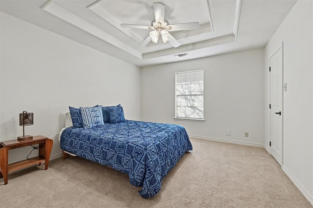 304 Trollinger Street Whitesboro, TX 76273 - Photo 17 of 25 a bedroom with a bed chandelier and a window