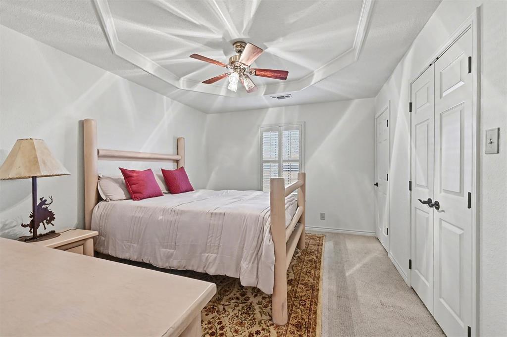 304 Trollinger Street Whitesboro, TX 76273 - Photo 19 of 25 a bedroom with bed and a chandelier