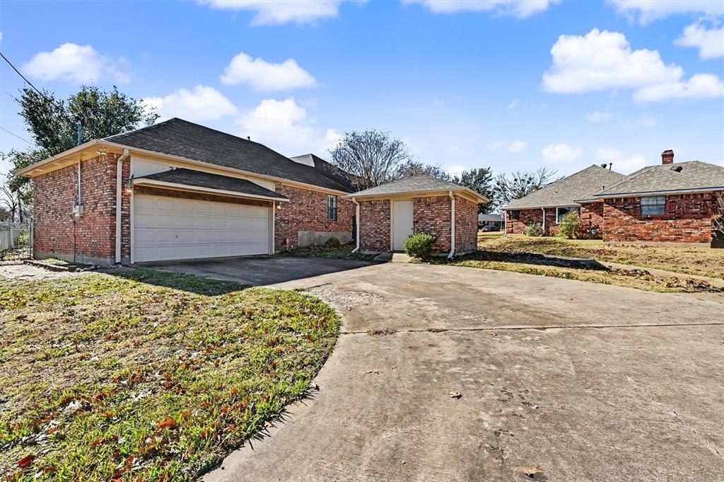 304 Trollinger Street Whitesboro, TX 76273 - Photo 23 of 25 a front view of a house with a yard and garage