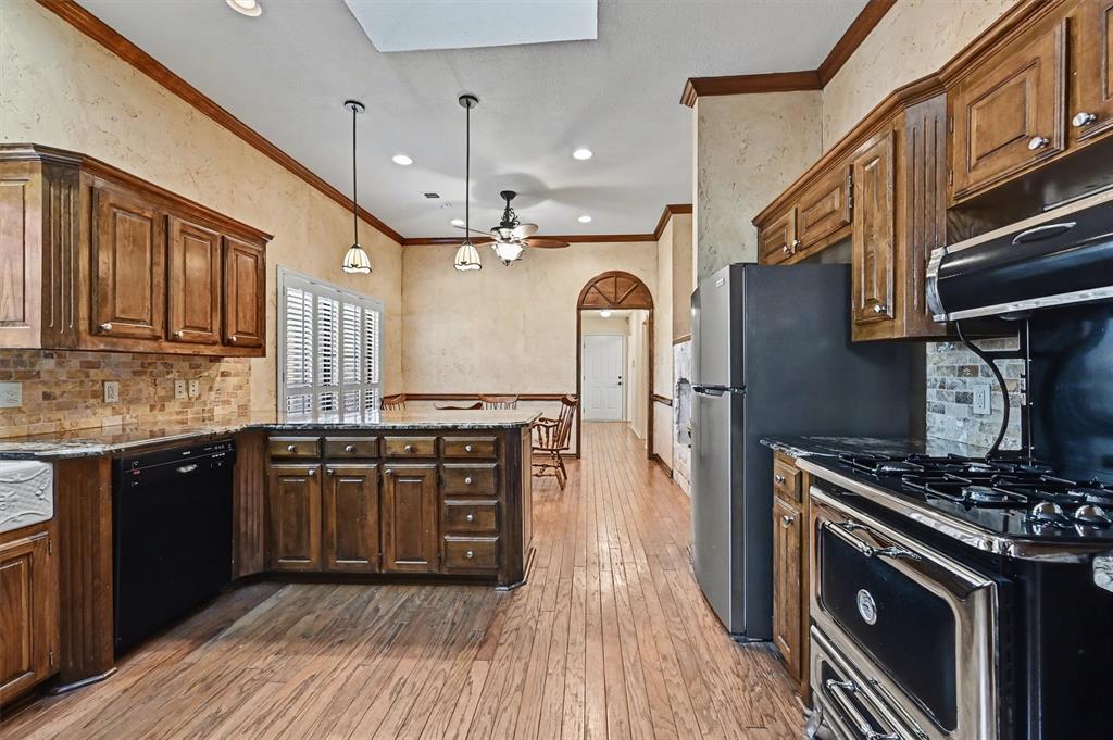 304 Trollinger Street Whitesboro, TX 76273 - Photo 5 of 25 a kitchen with stainless steel appliances granite countertop a stove and a sink