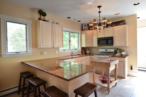 185 Weston Road Wellesley, MA 02482 - Photo 5 of 11 a kitchen with a stove a sink dishwasher a dining table and chairs with wooden floor