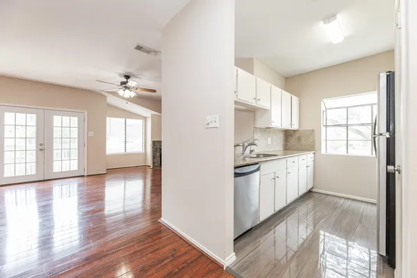 a kitchen with granite countertop white cabinets and a sink