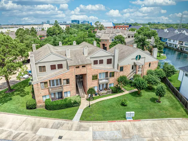 an aerial view of residential houses with yard and green space