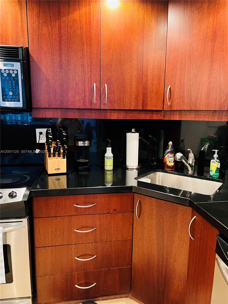2333 Brickell Avenue, Unit 1803 Miami, FL 33129 - Photo 21 of 23 a kitchen with stainless steel appliances granite countertop a refrigerator and a sink