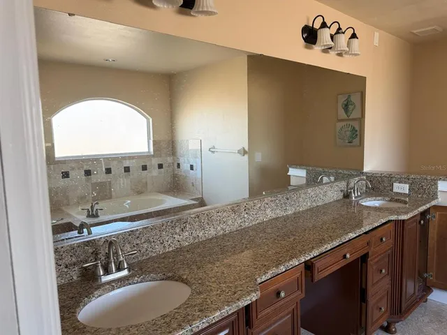 a bathroom with a granite countertop sink and a mirror