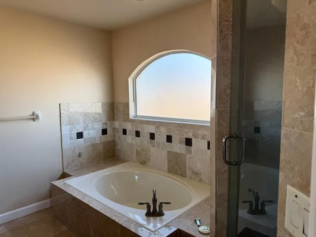 a bathroom with a tub and shower