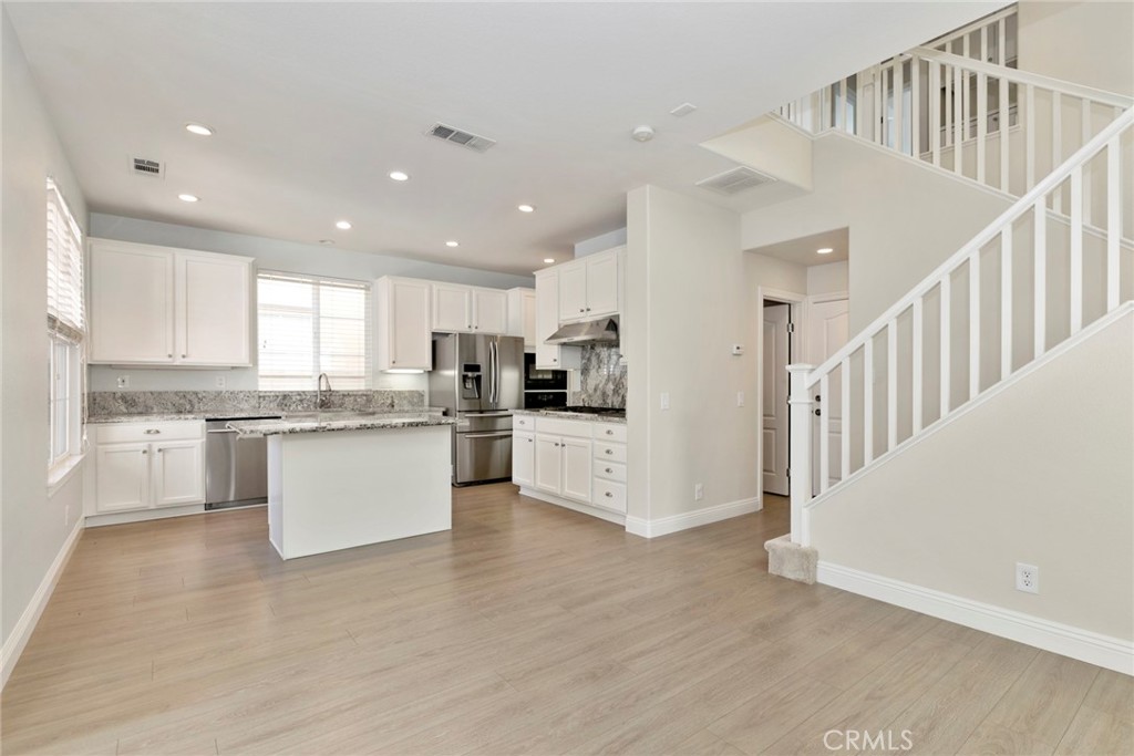 63 Figtree Irvine, CA 92603 - Photo 7 of 14 a kitchen with granite countertop white cabinets and stainless steel appliances
