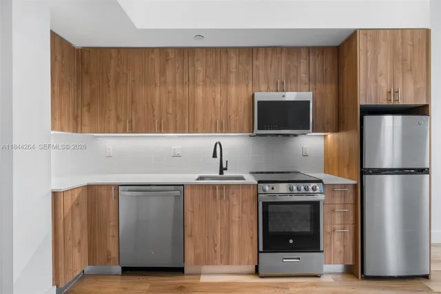 a kitchen with stainless steel appliances a stove a microwave and a refrigerator