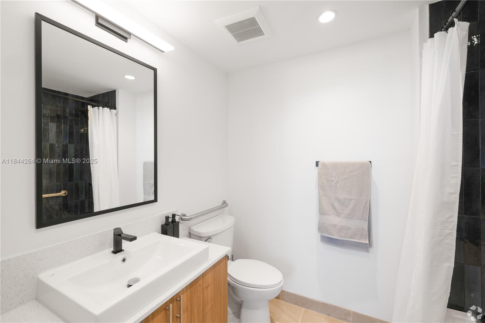 650 Southwest 1st Street, Unit 203 Miami, FL 33130 - Photo 7 of 15 a bathroom with a toilet sink and mirror