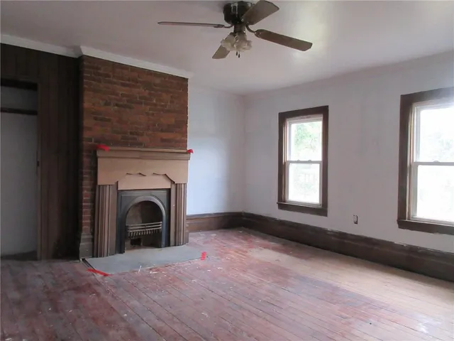 an empty room with windows dryer and fireplace