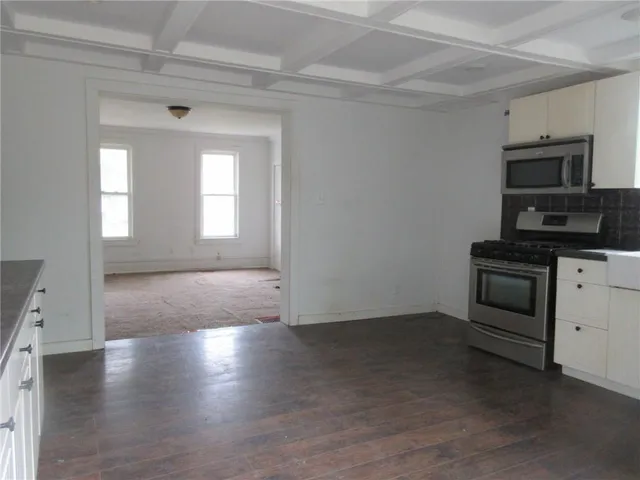 a view of empty room with a fireplace and wooden floor