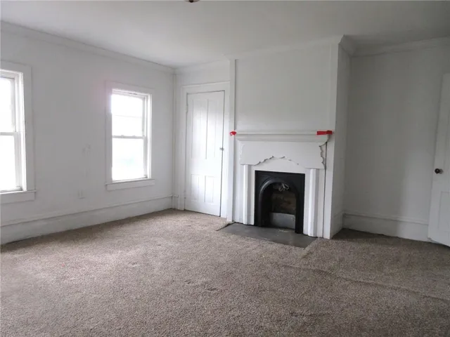 an empty room with a fireplace and window