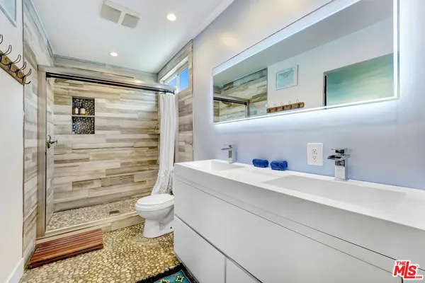 a bathroom with a sink a toilet and mirror