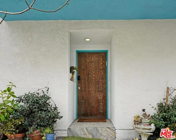 a view of a hallway with wooden floor and a potted plant