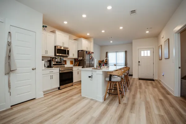 a kitchen with white cabinets and appliances