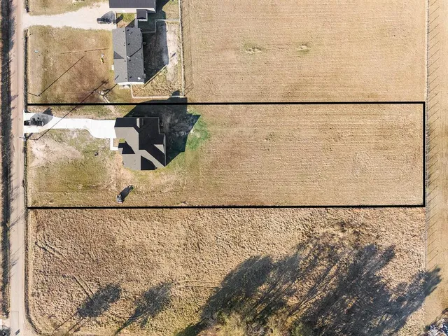 a front view of house with yard and trees in the background