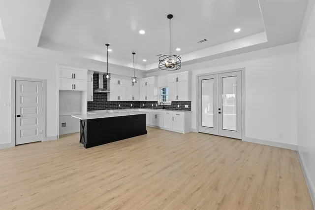 a large kitchen with stainless steel appliances kitchen island a cabinets and wooden floor