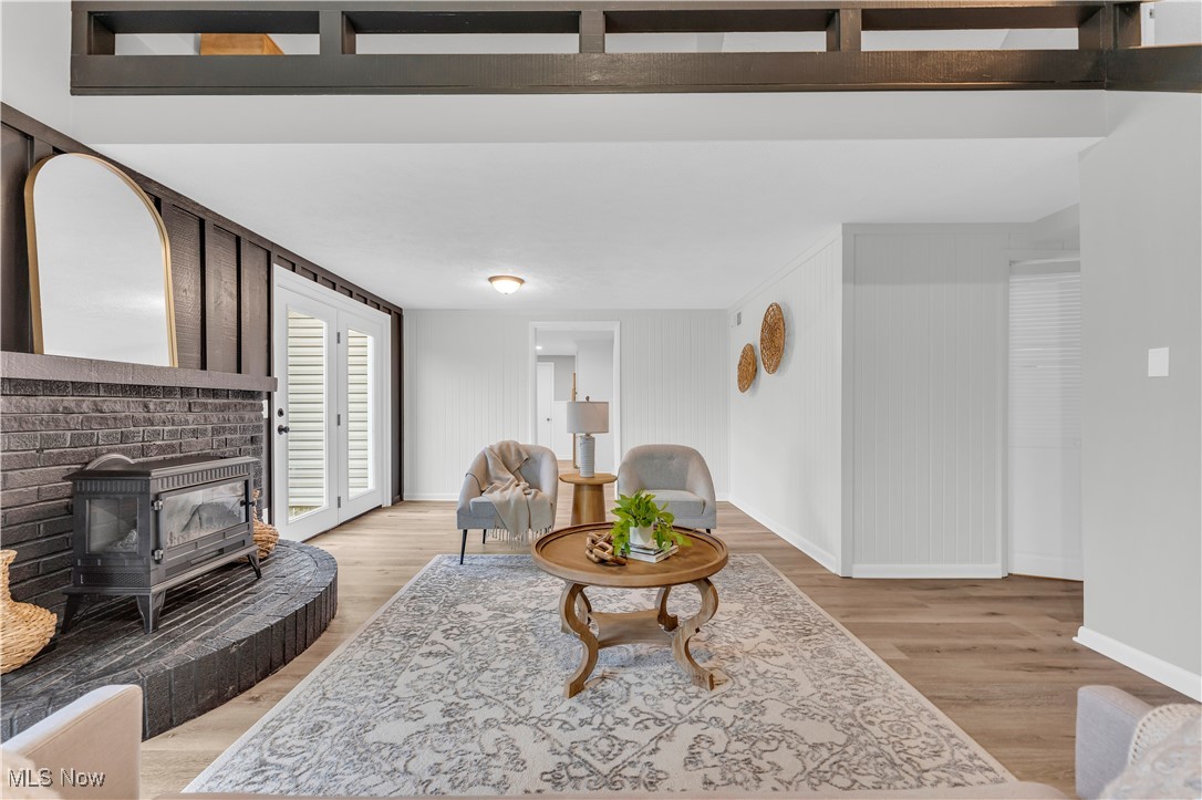 6920 Joppa Road Vermilion, OH 44089 - Photo 15 of 38 Living room featuring light hardwood / wood-style floors and a wood stove