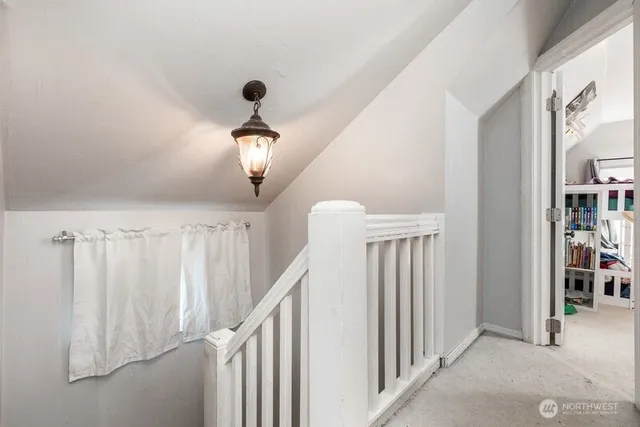 a very nice looking hallway with a large window and chandelier fan