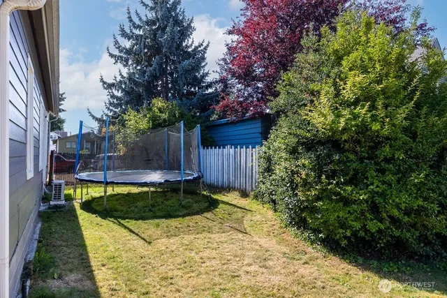 a view of a backyard with table and chairs and wooden fence