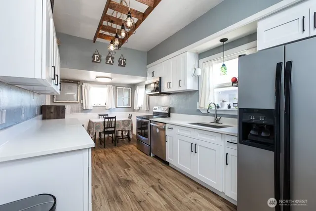 a kitchen with stainless steel appliances a refrigerator sink and cabinets