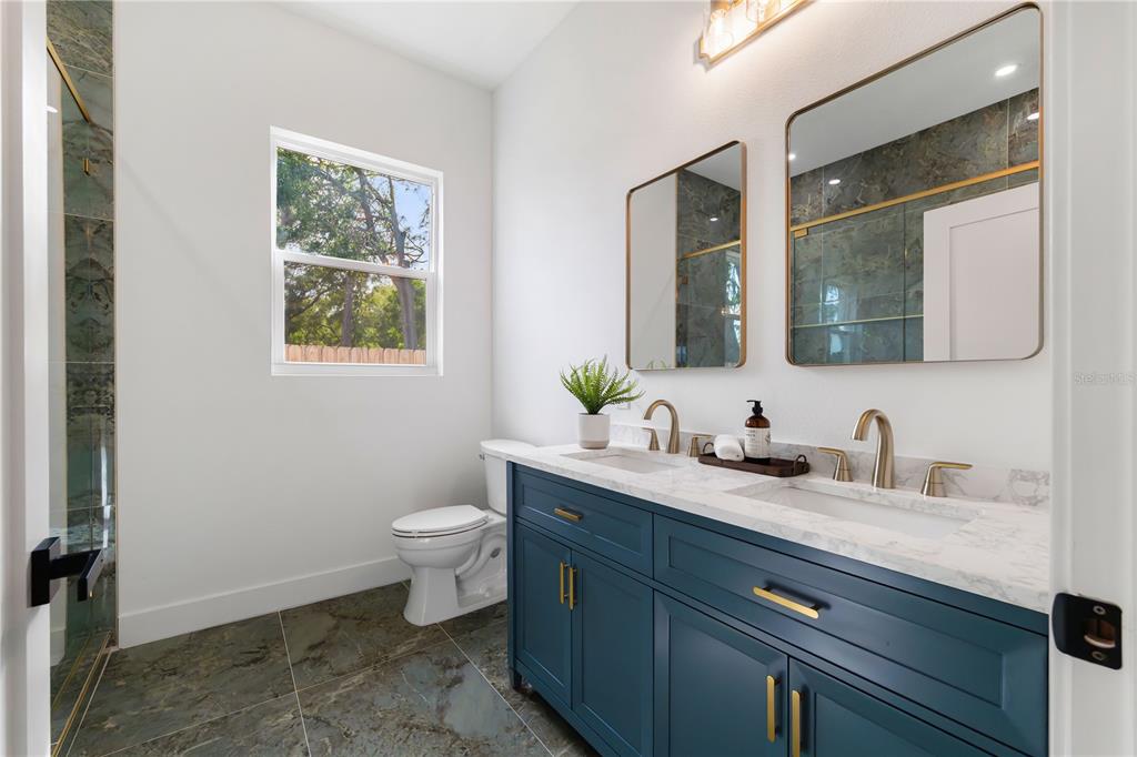 15364 Newport Road Clearwater, FL 33764 - Photo 30 of 50 a bathroom with a granite countertop toilet sink and mirror