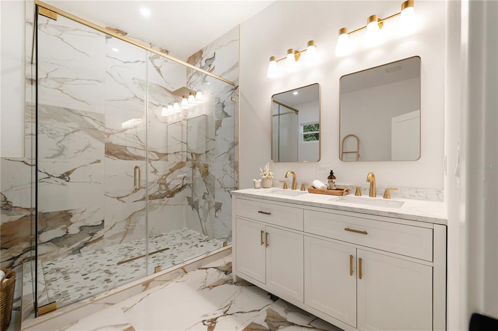 15364 Newport Road Clearwater, FL 33764 - Photo 38 of 50 a bathroom with a granite countertop sink a mirror and shower