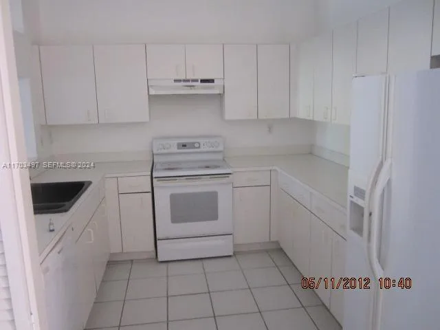 a kitchen with white cabinets and white appliances