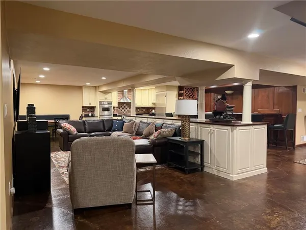 a living room with lots of furniture and kitchen view