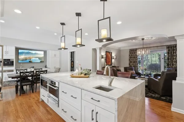 a view of a kitchen counter space dining table wooden floor and a large window